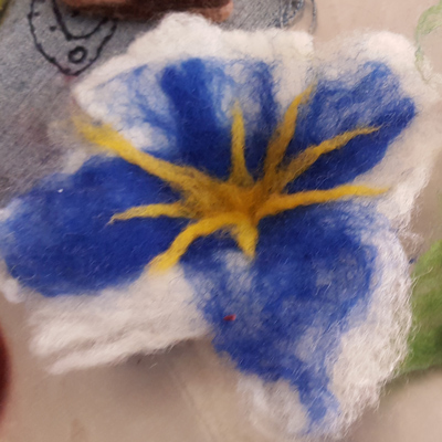picture f a bluew white and wellow flower made with wet felting technique