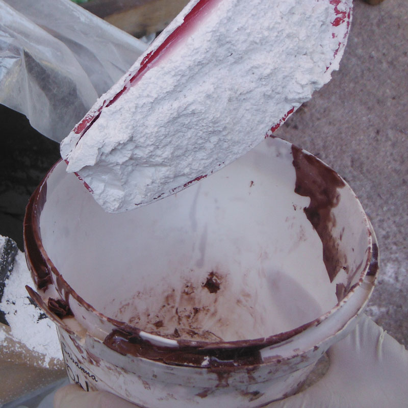 spooning kulu powder into  mixing tub