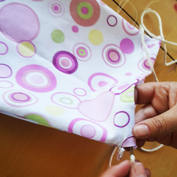 push twine though top of drawsting bag