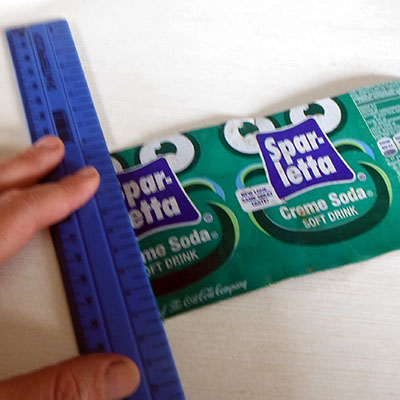 placing ruler on can to mark cutting points
