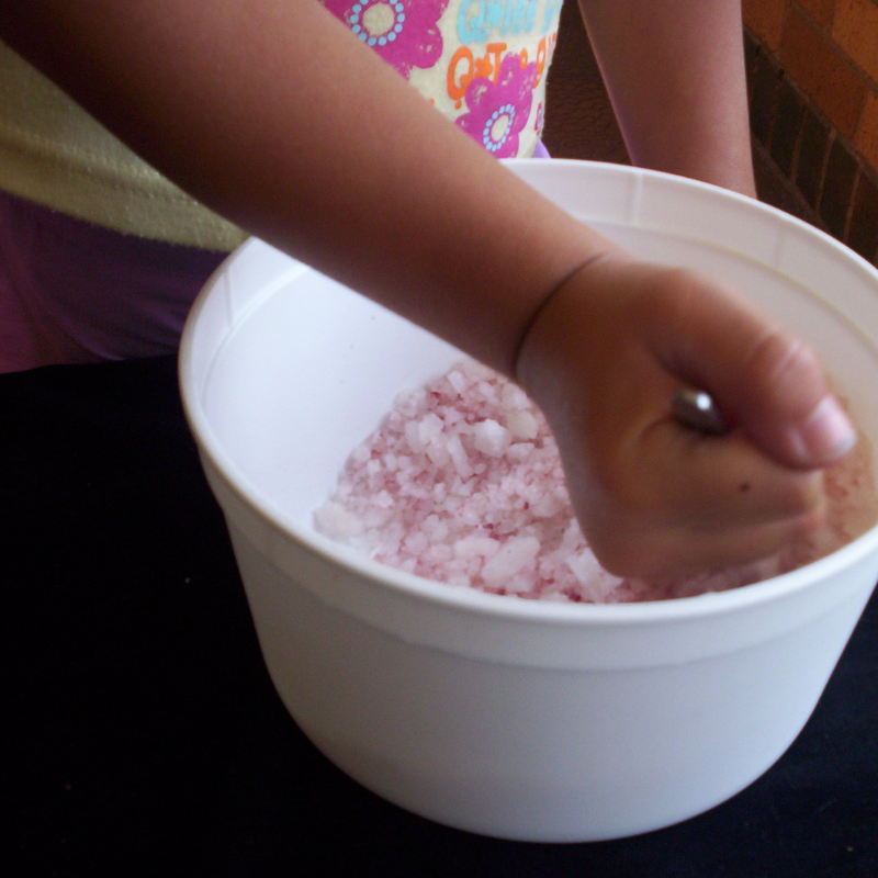 mixing red food colouring into course salt
