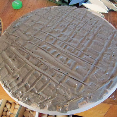 spreading tile cement evenly over stepping stone