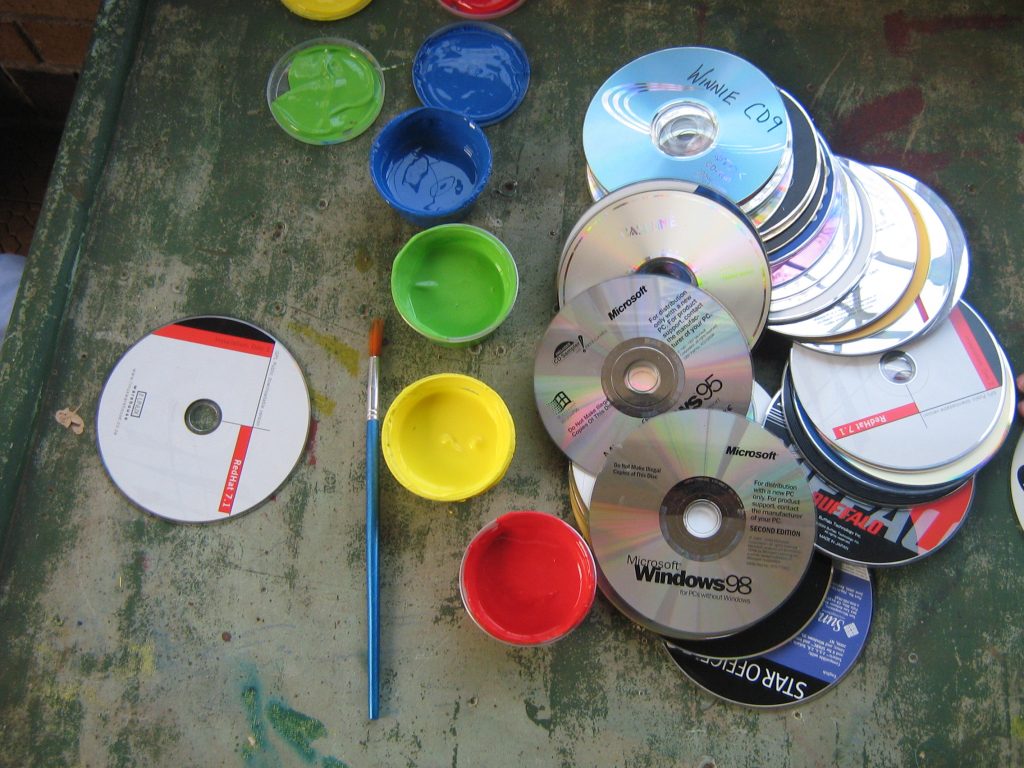 a pile of cds with paint in different colours