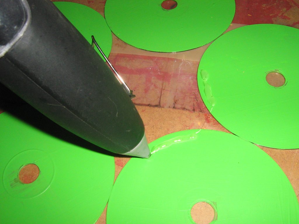 adding glue from the glue gun onto the cd